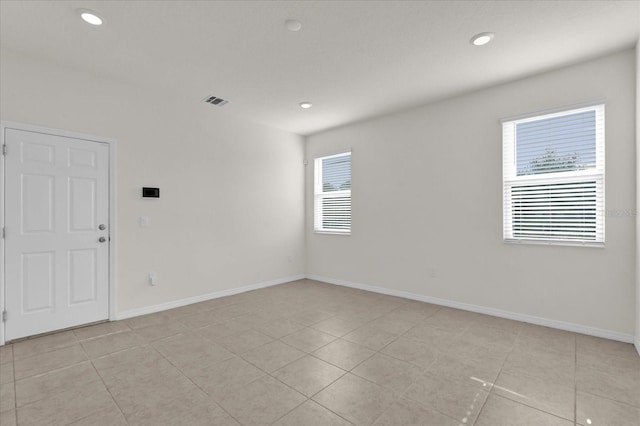 unfurnished room featuring light tile patterned floors, recessed lighting, and baseboards
