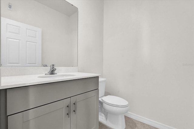 bathroom with baseboards, tile patterned floors, toilet, and vanity