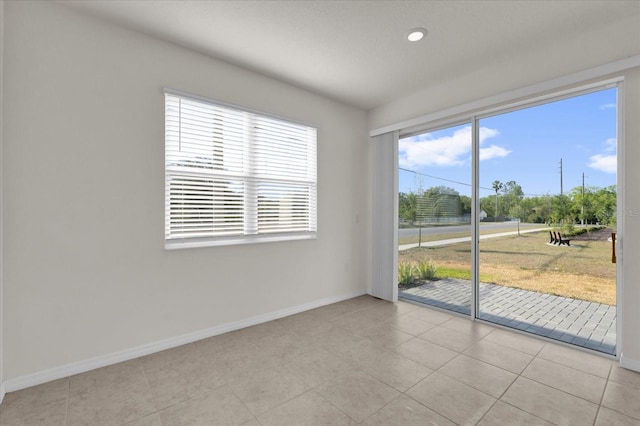 unfurnished room featuring recessed lighting, light tile patterned flooring, and baseboards