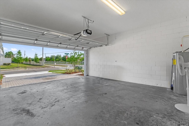 garage with concrete block wall, water heater, and a garage door opener