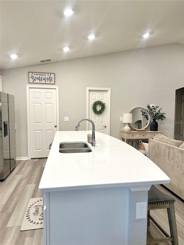 2000 Golden Beak Dr, Eagle Lake, FL 33839 - kitchen with a sink, light wood-style floors, light countertops, visible vents, and a center island with sink
