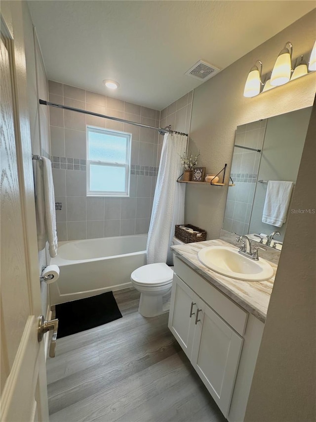 2000 Golden Beak Dr, Eagle Lake, FL 33839 - bathroom with vanity, toilet, wood finished floors, shower / tub combo, and visible vents