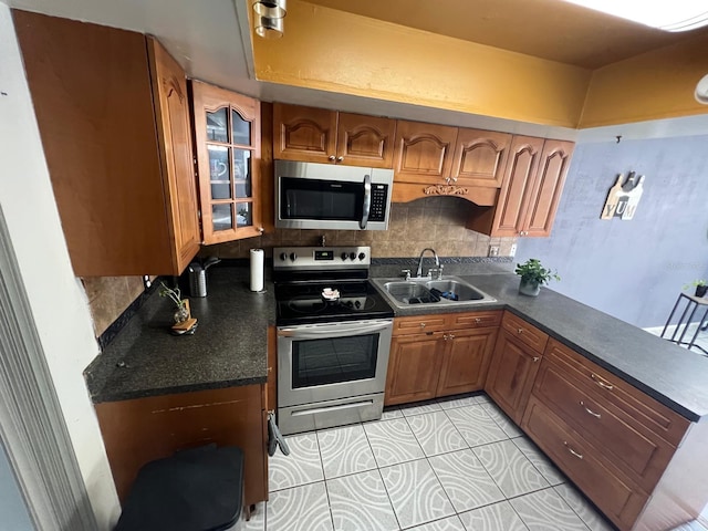 68 S Marbrisa Way, Kissimmee, FL 34743 - kitchen with brown cabinetry, dark countertops, tasteful backsplash, a sink, and stainless steel appliances