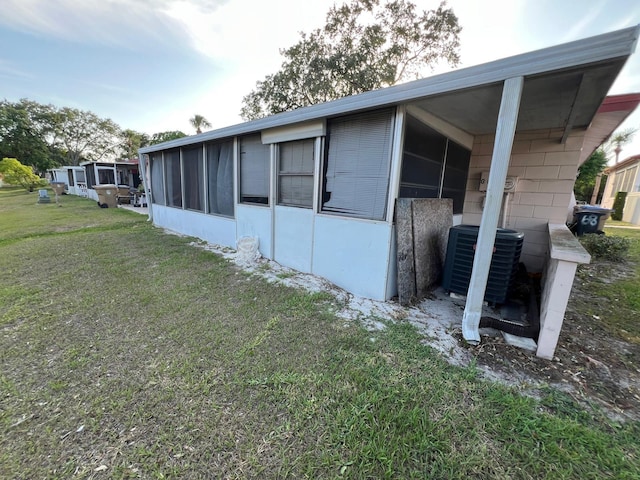 68 S Marbrisa Way, Kissimmee, FL 34743 - view of property exterior with central air condition unit, a yard, and a sunroom