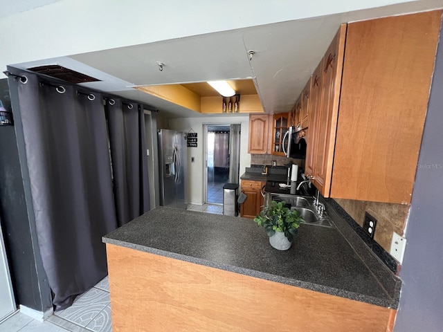 68 S Marbrisa Way, Kissimmee, FL 34743 - kitchen with a peninsula, light tile patterned flooring, dark countertops, a sink, and appliances with stainless steel finishes