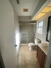full bathroom with tile patterned floors, a shower stall, toilet, and vanity