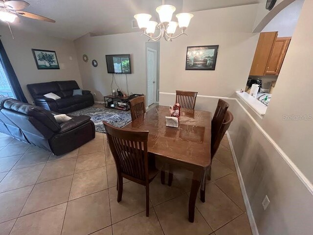 dining room featuring light tile patterned floors and ceiling fan with notable chandelier
