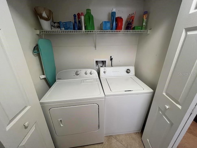 laundry area featuring light tile patterned floors, washer and dryer, and laundry area