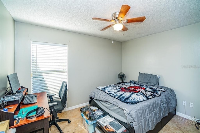 bedroom featuring baseboards, light tile patterned floors, ceiling fan, and a textured ceiling