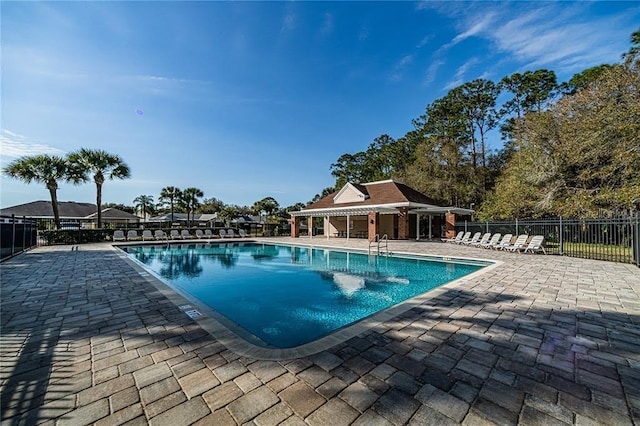 community pool featuring fence and a patio area