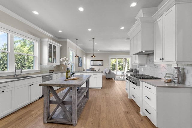 kitchen with recessed lighting, appliances with stainless steel finishes, a sink, white cabinetry, and a peninsula
