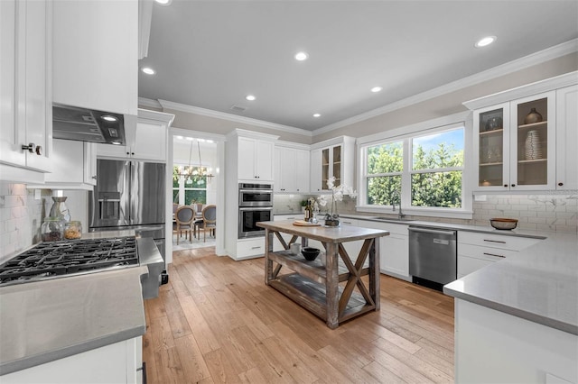 kitchen featuring white cabinets, stainless steel appliances, backsplash, and crown molding