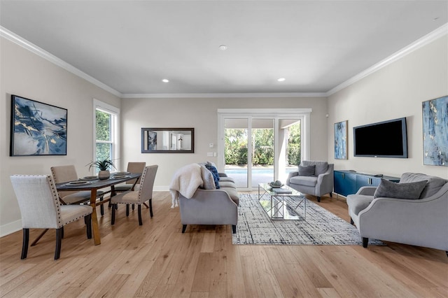 living area featuring ornamental molding, light wood-style floors, and plenty of natural light