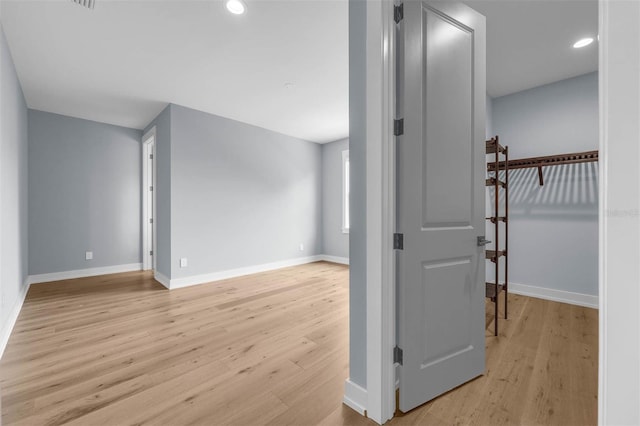 hall featuring recessed lighting, light wood-style flooring, and baseboards