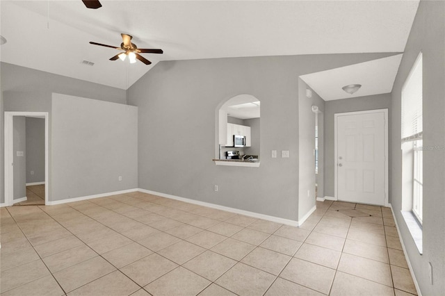 4347 Creekside Blvd, Kissimmee, FL 34746 - spare room featuring light tile patterned floors, lofted ceiling, a ceiling fan, arched walkways, and baseboards