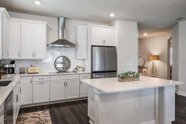 kitchen featuring wall chimney range hood, visible vents, stainless steel appliances, white cabinetry, and dark wood-type flooring