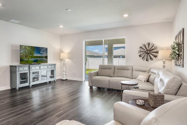 living area with a textured ceiling, visible vents, wood finished floors, baseboards, and recessed lighting