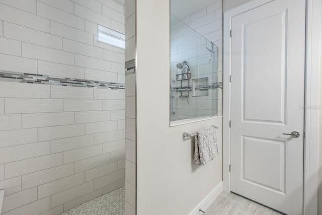 bathroom with a walk in shower and baseboards