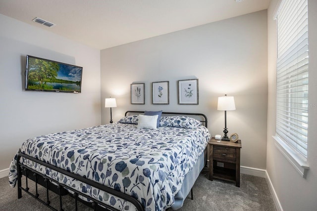 bedroom with baseboards, carpet flooring, and multiple windows