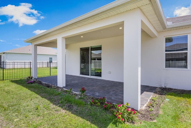 back of house featuring a yard, fence, a patio area, and stucco siding