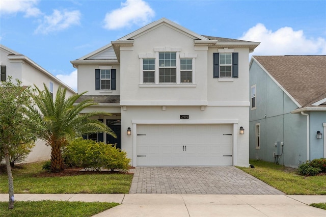 traditional home with driveway, a garage, and stucco siding
