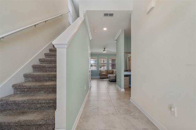stairway featuring tile patterned floors, visible vents, a ceiling fan, and baseboards