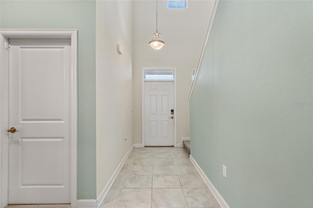 doorway featuring baseboards and stairway