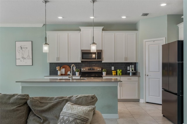 kitchen featuring a sink, visible vents, backsplash, hanging light fixtures, and appliances with stainless steel finishes