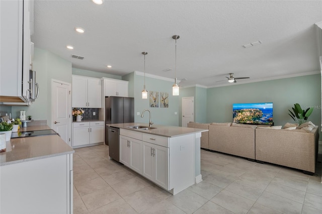 kitchen with appliances with stainless steel finishes, backsplash, a sink, white cabinetry, and a ceiling fan
