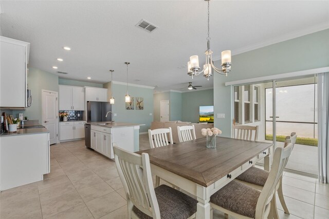 dining room featuring light tile patterned floors, visible vents, crown molding, and ceiling fan with notable chandelier