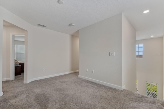 carpeted spare room with recessed lighting, visible vents, and baseboards