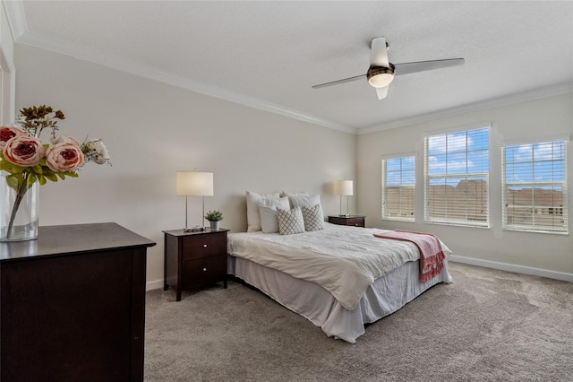 carpeted bedroom with baseboards, ornamental molding, and a ceiling fan
