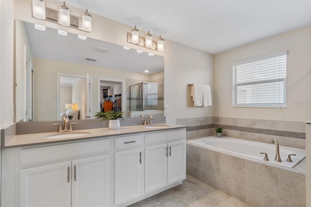 full bathroom featuring a stall shower, a garden tub, double vanity, and a sink