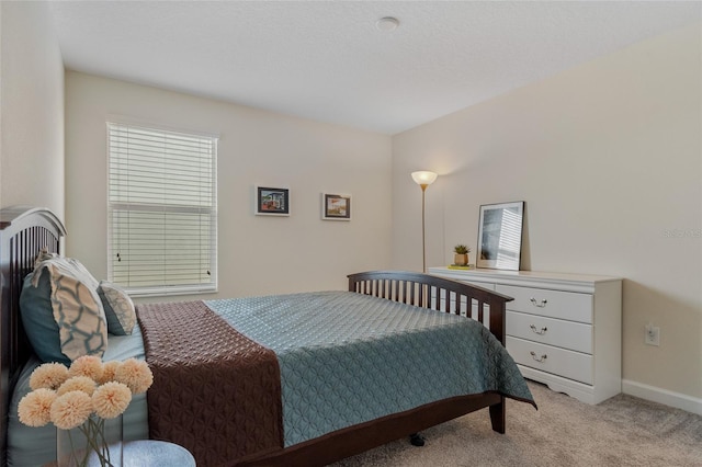 bedroom featuring light carpet and baseboards