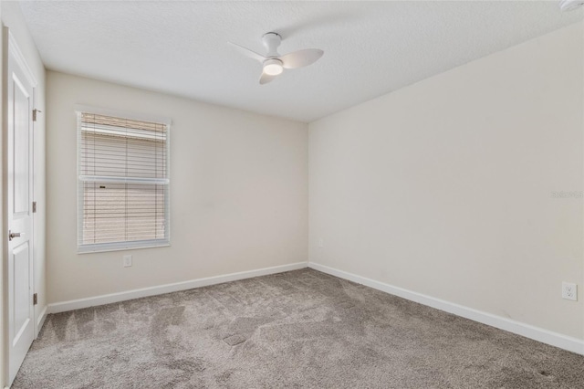 carpeted spare room featuring baseboards and ceiling fan