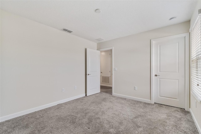unfurnished bedroom featuring carpet flooring, visible vents, and baseboards