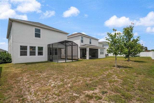 back of house featuring a patio, a yard, a lanai, stucco siding, and fence