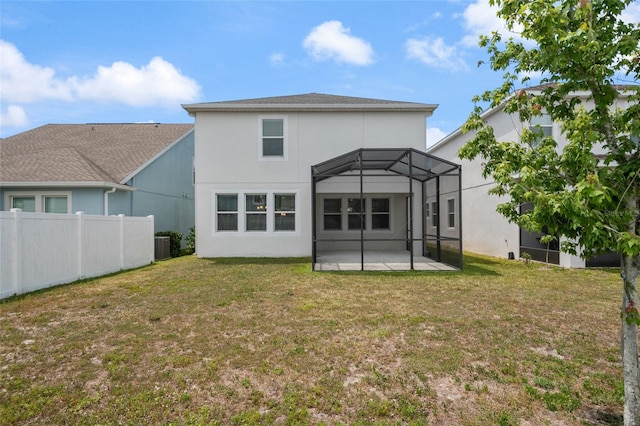 back of property featuring stucco siding, fence, a yard, and a patio