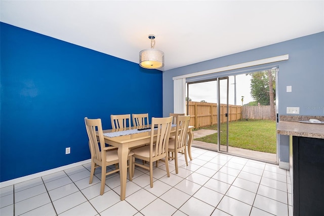 dining space featuring light tile patterned flooring and baseboards