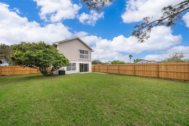 rear view of house with a yard, central air condition unit, and a fenced backyard