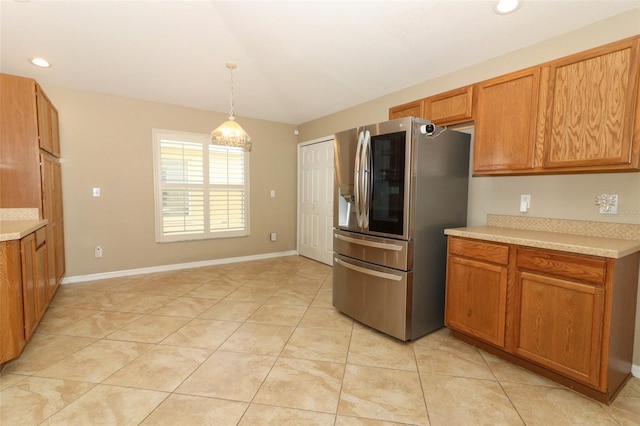 212 Regency St, Davenport, FL 33896 - kitchen with stainless steel fridge, light countertops, brown cabinetry, and light tile patterned floors