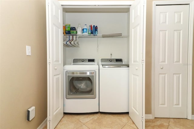 212 Regency St, Davenport, FL 33896 - washroom featuring washer and dryer, laundry area, baseboards, and light tile patterned floors