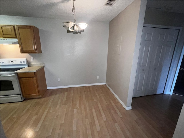 kitchen with brown cabinets, white range with electric stovetop, ventilation hood, baseboards, and light wood-type flooring