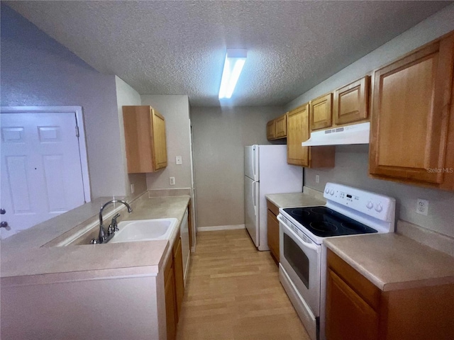kitchen with a textured ceiling, a sink, light countertops, under cabinet range hood, and white appliances