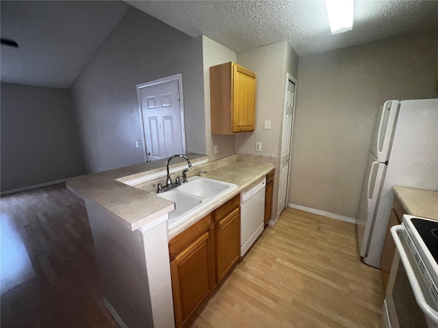kitchen with white appliances, a textured ceiling, a sink, and light wood finished floors