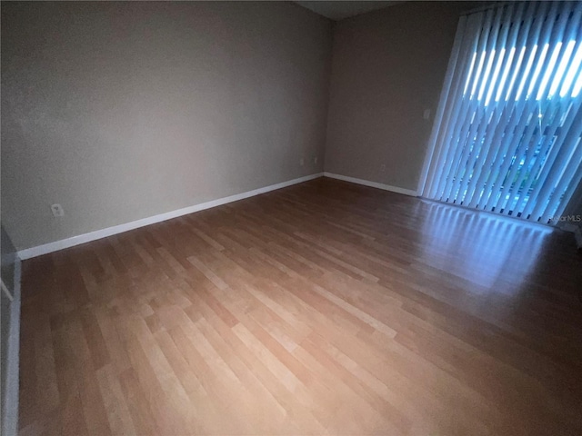 empty room featuring baseboards and wood finished floors