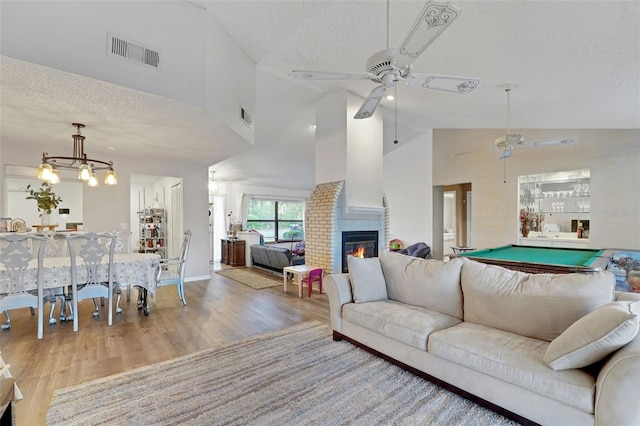 516 Fort Smith Blvd, Deltona, FL 32738 - living area featuring ceiling fan, high vaulted ceiling, wood finished floors, a textured ceiling, and a glass covered fireplace