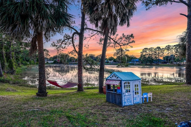 516 Fort Smith Blvd, Deltona, FL 32738 - yard at dusk featuring a lawn, a water view, an outdoor structure, and exterior structure