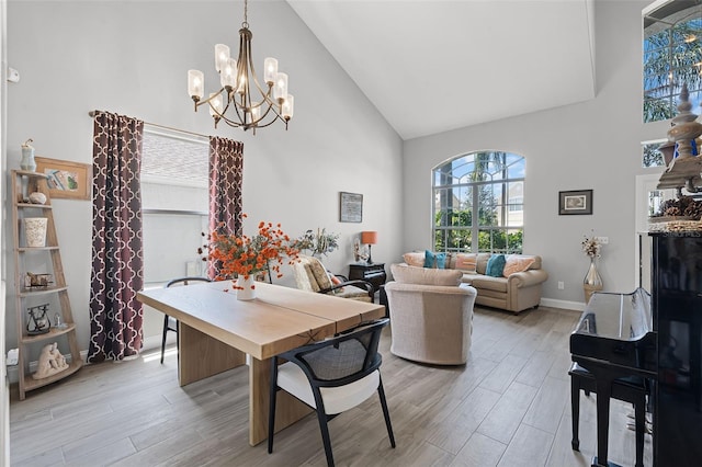 4027 Lakeside Reserve Ct, Orlando, FL 32810 - dining room featuring an inviting chandelier, light wood-type flooring, baseboards, and high vaulted ceiling