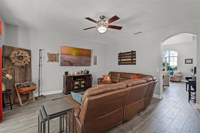 4027 Lakeside Reserve Ct, Orlando, FL 32810 - living room featuring arched walkways, ceiling fan, light wood finished floors, and visible vents